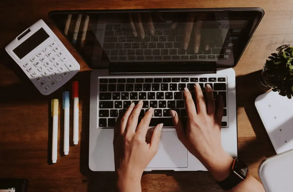 hands on laptop keyboard